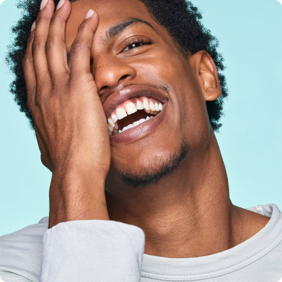 Man Smiling With Hand On Head